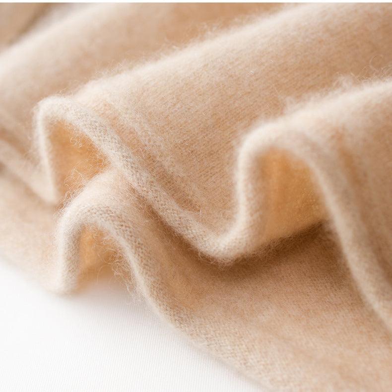 Beige knit sweater fabric close-up with visible heathered yarn texture.