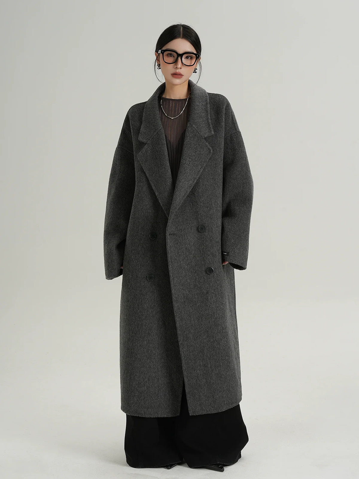 Long dark gray double-breasted wool coat with notch lapels and button front, front view