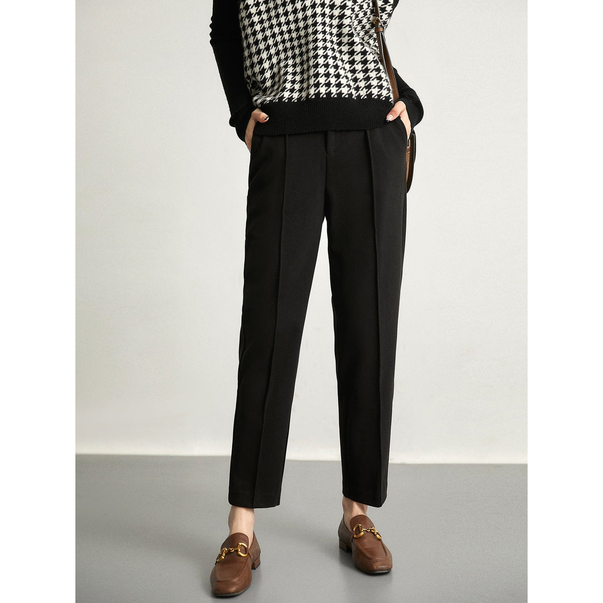 Black tapered trousers with high waist, belt loops, and front pleats