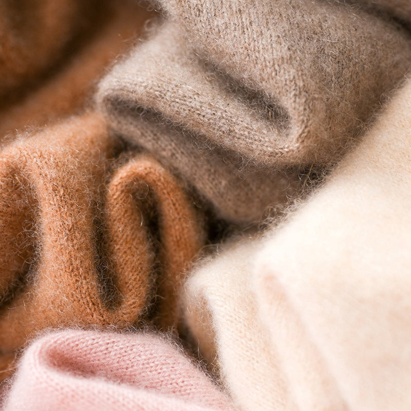Knit fabric close-up of turtleneck sweater with warm brown and cream yarn