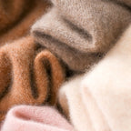 Knit fabric close-up of turtleneck sweater with warm brown and cream yarn