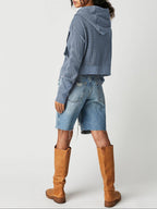 Blue waffle knit zip hoodie from back with hood; worn with denim shorts and boots.
