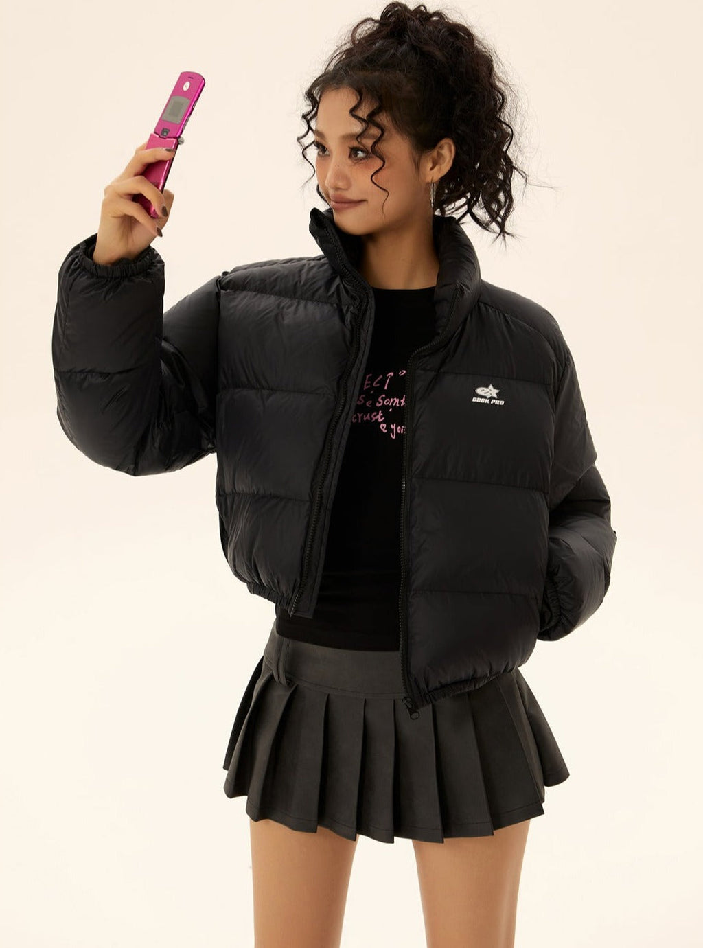 Black short puffer jacket with front pockets, full-zip front, and chest logo