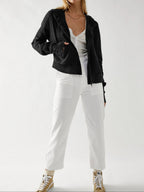 Black waffle knit zip hoodie with hood worn open over a white top.