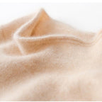 Ivory knit fabric close-up with soft texture on a slim fit turtleneck sweater.