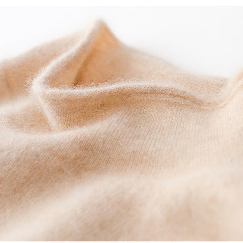 Ivory knit fabric close-up with soft texture on a slim fit turtleneck sweater.
