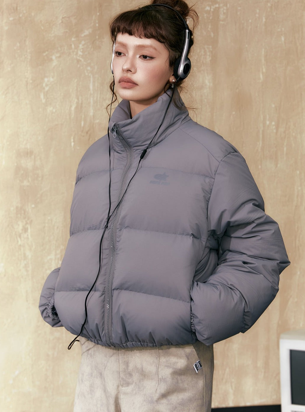 Gray short puffer jacket in a structured puffer silhouette with full-zip front