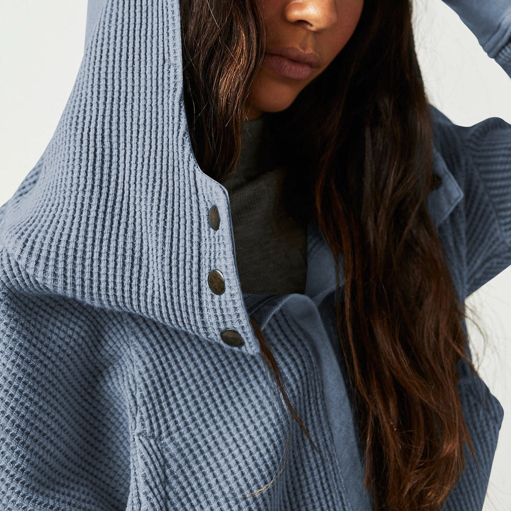 Close-up of blue waffle hoodie hood with dark buttons and knit texture.