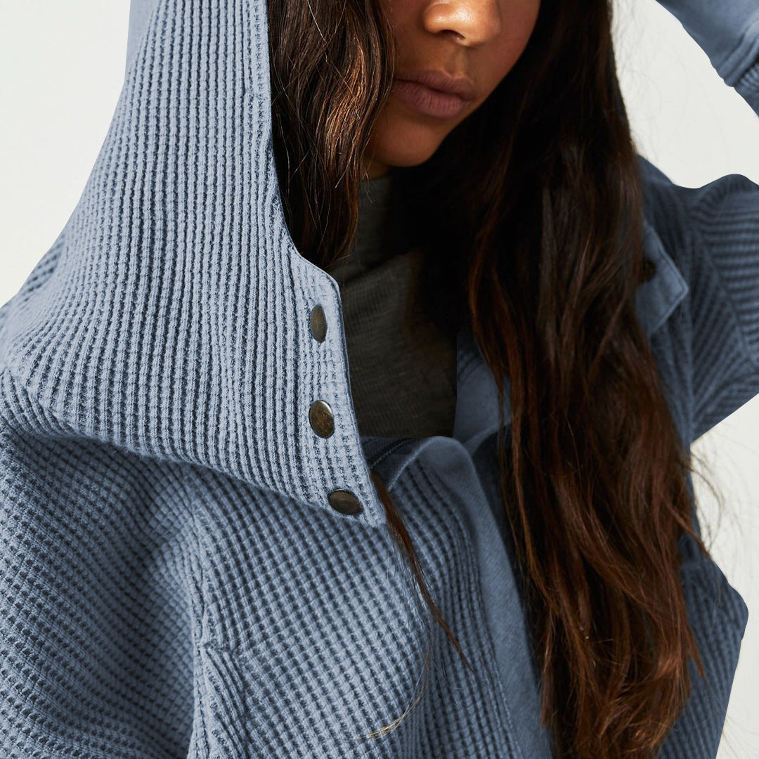 Close-up of blue waffle hoodie hood with dark buttons and knit texture.