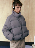 Gray short puffer jacket with full-zip front, stand collar, and side pockets