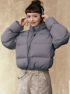 Gray short puffer jacket with full-zip front, stand collar, and drawstring hem