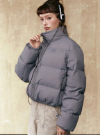 Gray short puffer jacket, full-zip front, stand collar, and elastic cuff details