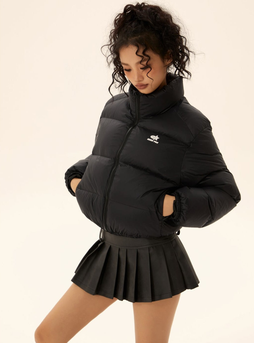 Black short puffer jacket with stand collar, full-zip front, and quilted puff sleeves