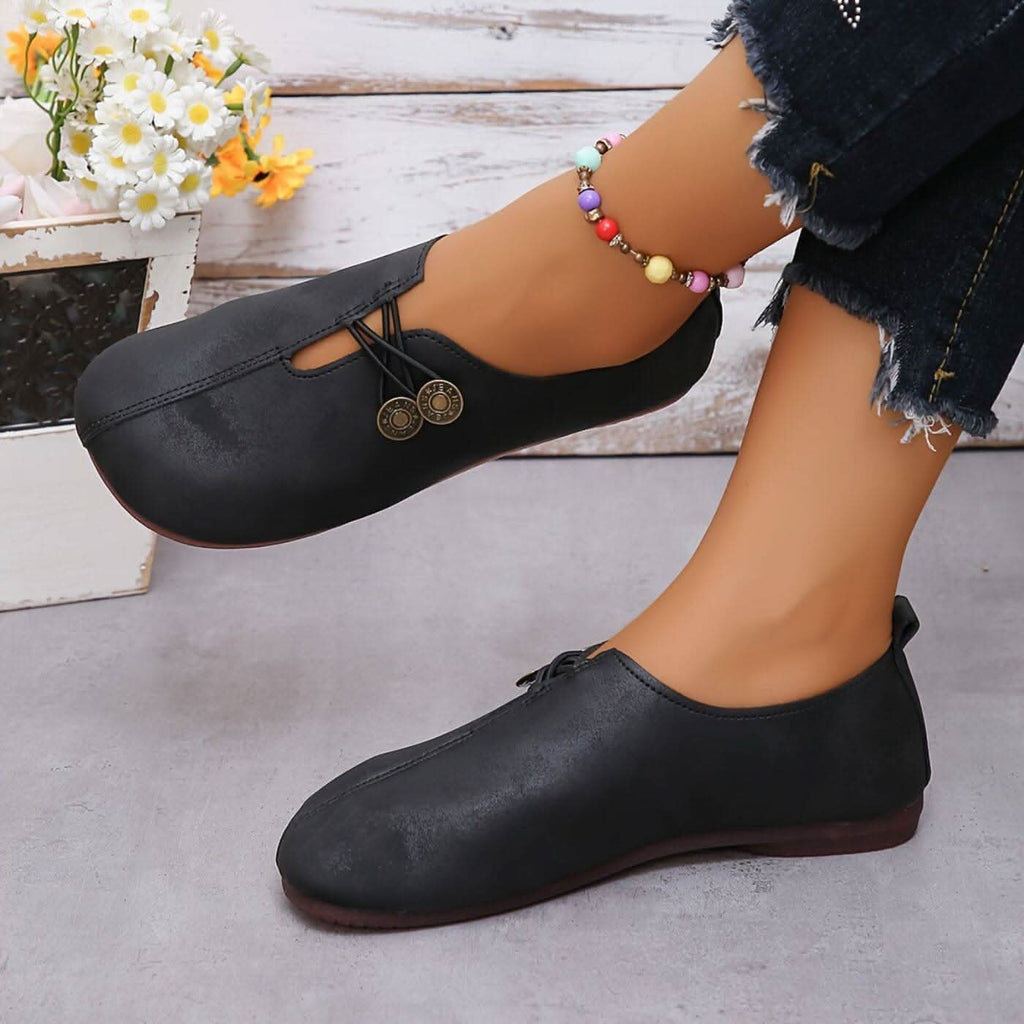 Women’s lightweight walking shoes in black with round coin accents and lace-up front