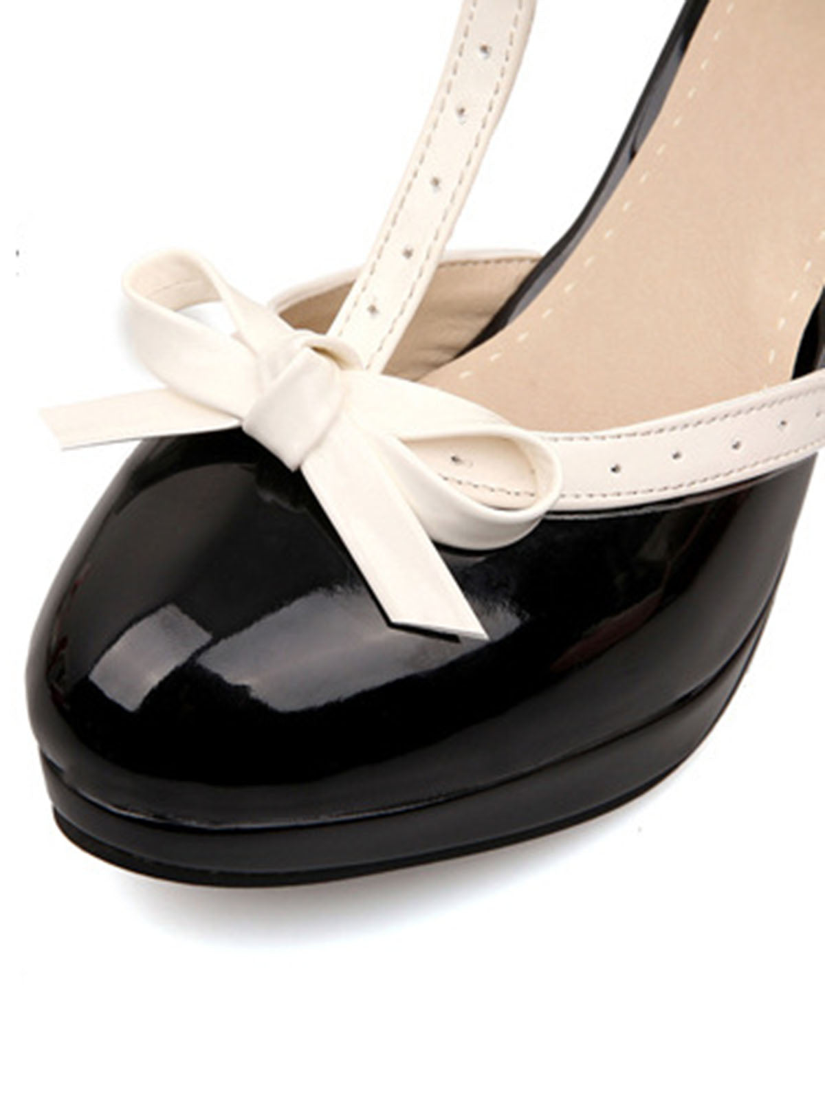 Black patent high heels with white ankle strap and bow detail at the toe