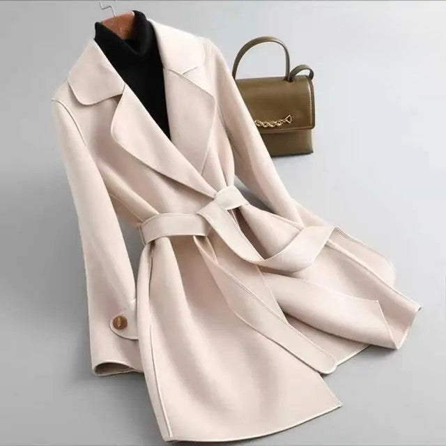 Cream overcoat with wide lapels, waist belt, and gold button accents