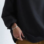 Black high-neck casual top sleeve with relaxed cuff and draped fabric