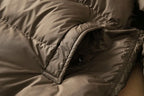 Long down puffer parka with quilted panels, zipper seam, and hood edge visible
