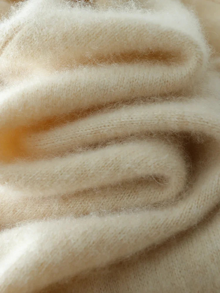 Cream beige knit sweater fabric close-up showing fuzzy yarn and ribbed rows