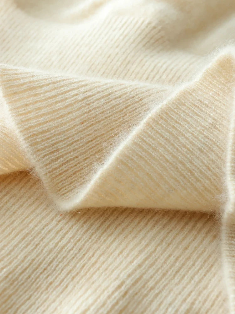 Light beige knit sweater fabric close-up with ribbed texture and gentle creases