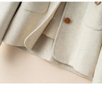 Ivory jacket close-up of patch pockets and button placket detail.