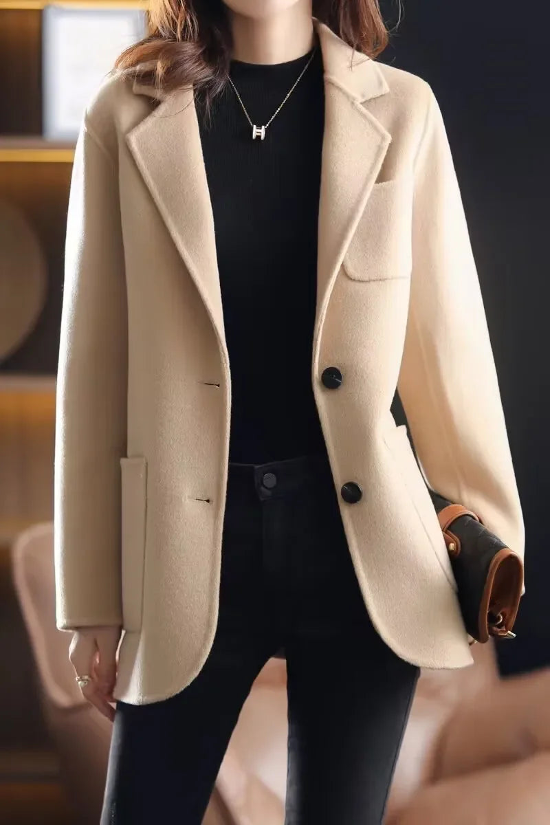 Ivory wool blazer with notched lapel, two-button front, side pockets, structured shoulders