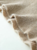 Close-up of beige ribbed cuff edge with visible knit pattern and texture
