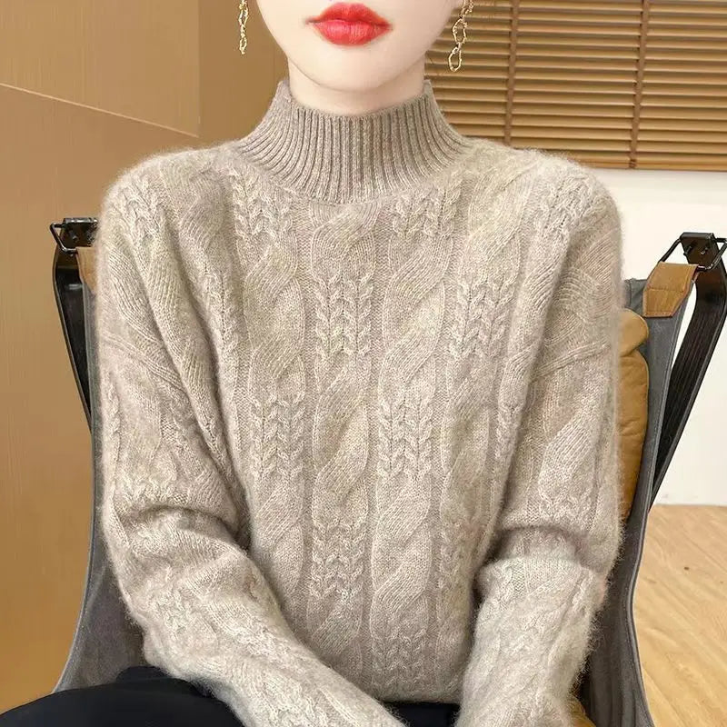 Cream cable knit mock neck sweater with dense cable details and ribbed knit neckline.