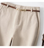 Off-white trousers waistband close-up with woven belt and gold-tone buckle
