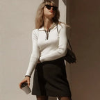 White ribbed knit zip sweater with long sleeves and quarter-zip front placket