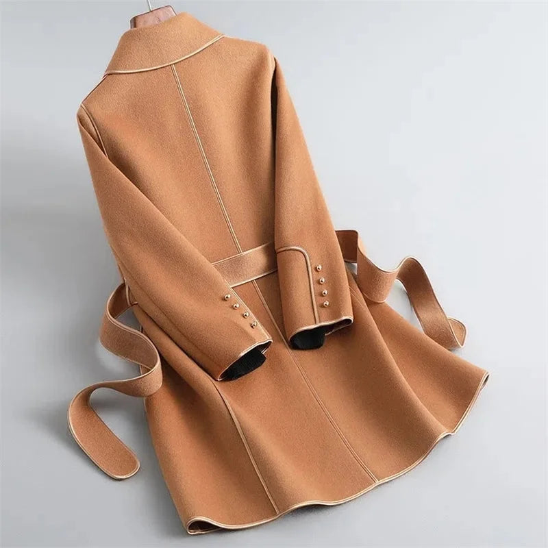 Womens tan long overcoat with belt tie, button details, and raised seam panels