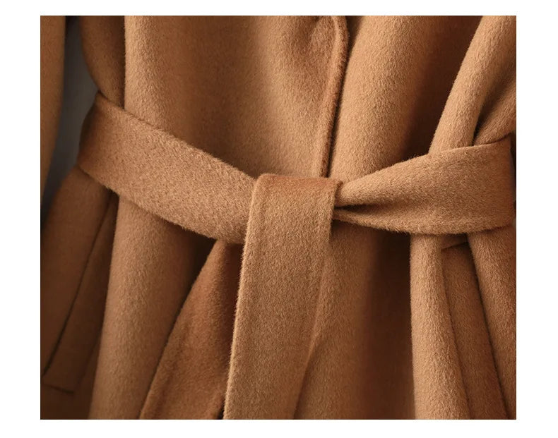 Camel belted wool midi coat close-up: tied waist belt and pleated drape