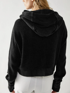 Black waffle knit zip hoodie with hood; back view and ribbed hem detail.