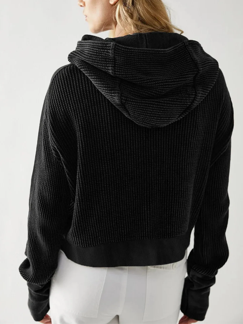 Black waffle knit zip hoodie with hood; back view and ribbed hem detail.