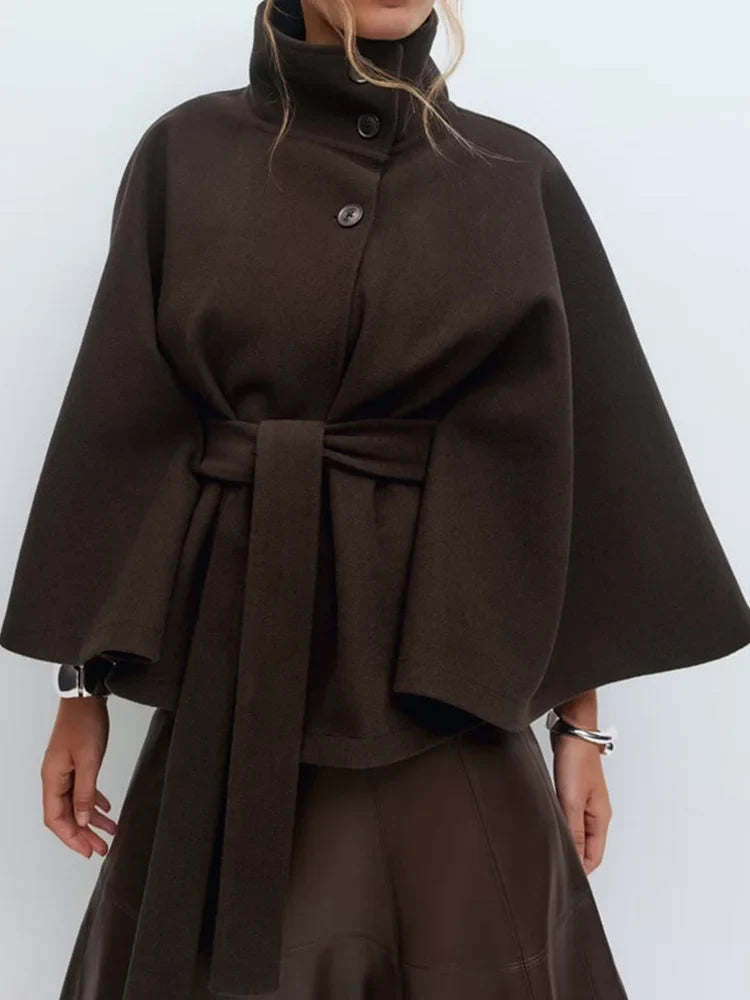 Chocolate brown wool-blend cape coat with stand collar, snap buttons, and waist belt