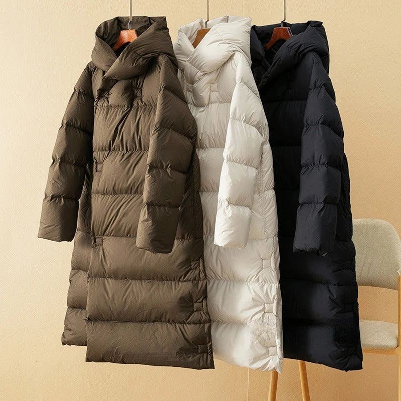 Long down puffer parkas in coffee, white, and black, each with a hood
