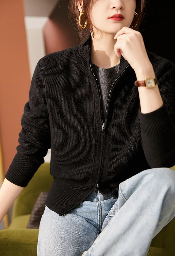 Black zip-up cardigan with ribbed knit texture and front zipper detail.