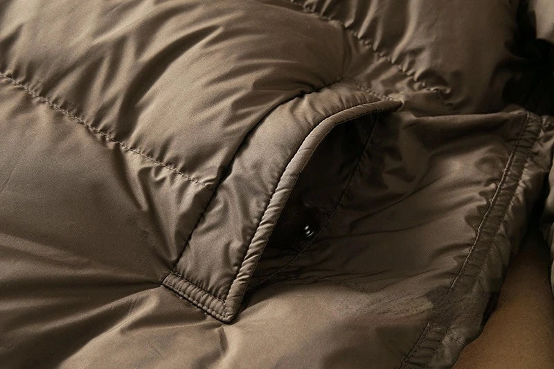 Long down puffer parka with hood, dark brown front with angled pocket and seam