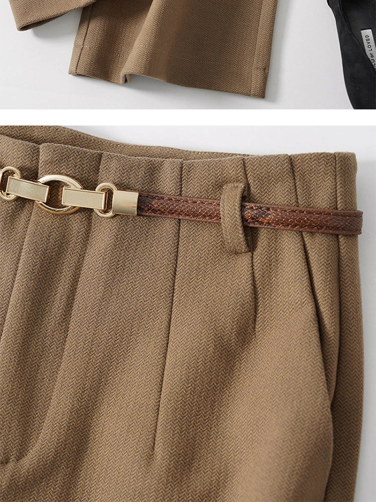 Tan trousers waistband close-up with chain-style belt and textured fabric