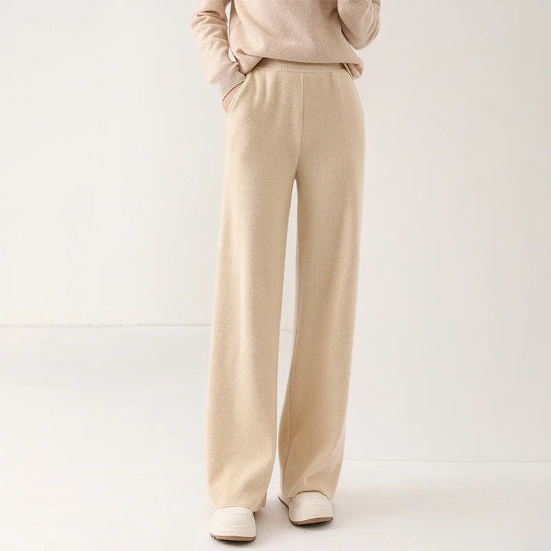 Light beige wide-leg knit pants with pull-on waistband and loose, straight leg fit.