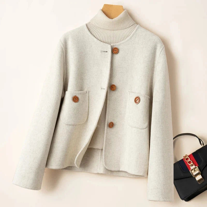 Light gray wool jacket with ribbed turtleneck, button placket, and two flap chest pockets