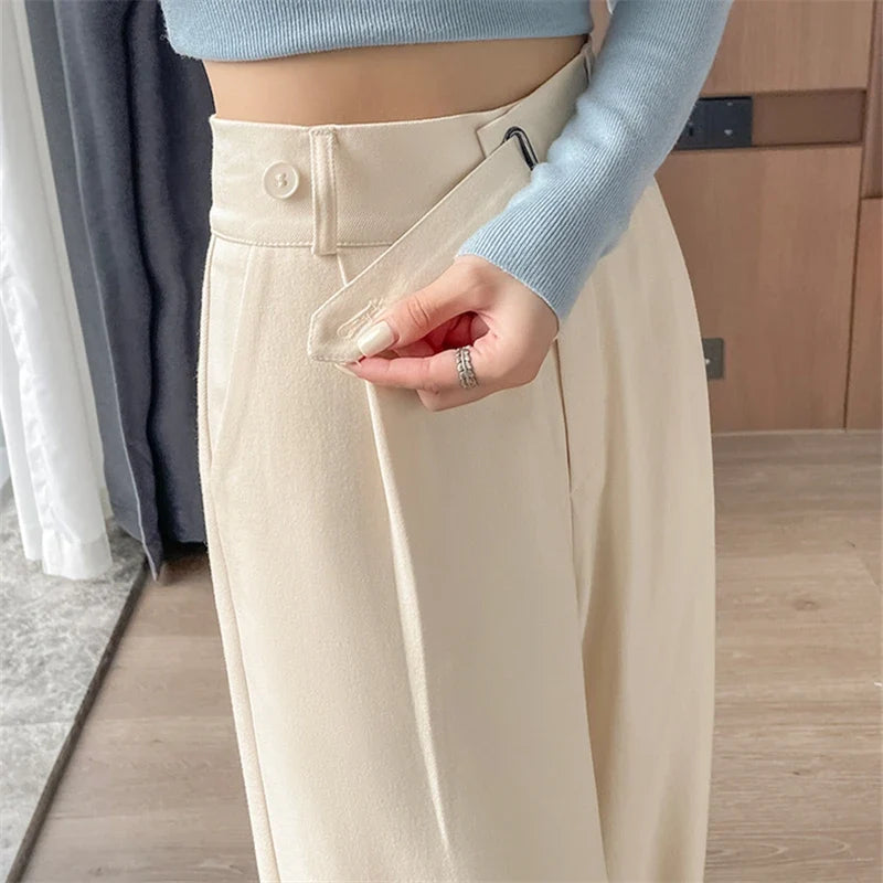 Women's high-rise wide-leg trousers, cream with button closure and pleated waist.