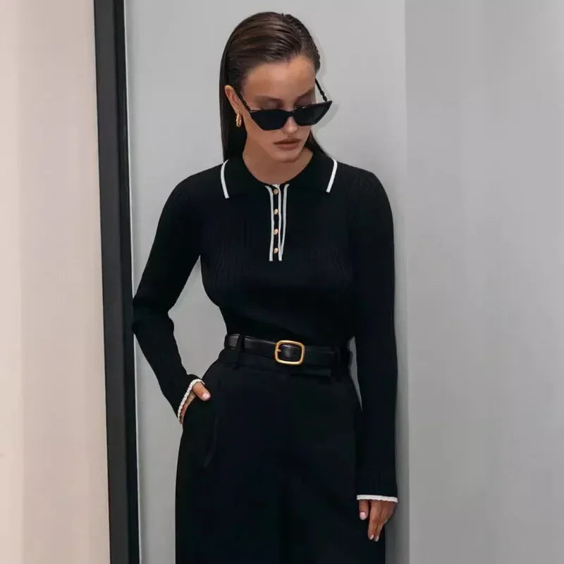 Black ribbed knit zip sweater with long sleeves and front zipper placket