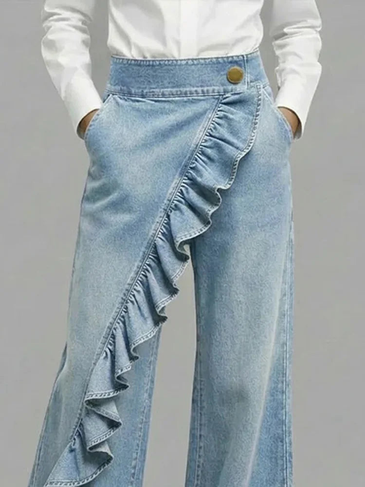 Light blue wide-leg jeans with diagonal ruffle overlay and gold button waistband