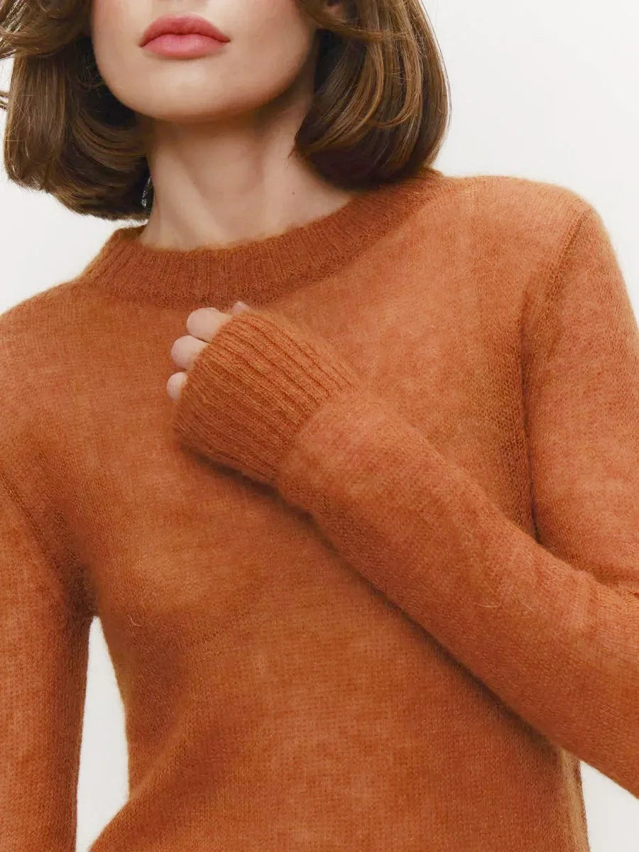 Lightweight crewneck knit sweater in rust orange, close-up of ribbed neckline and sleeve.