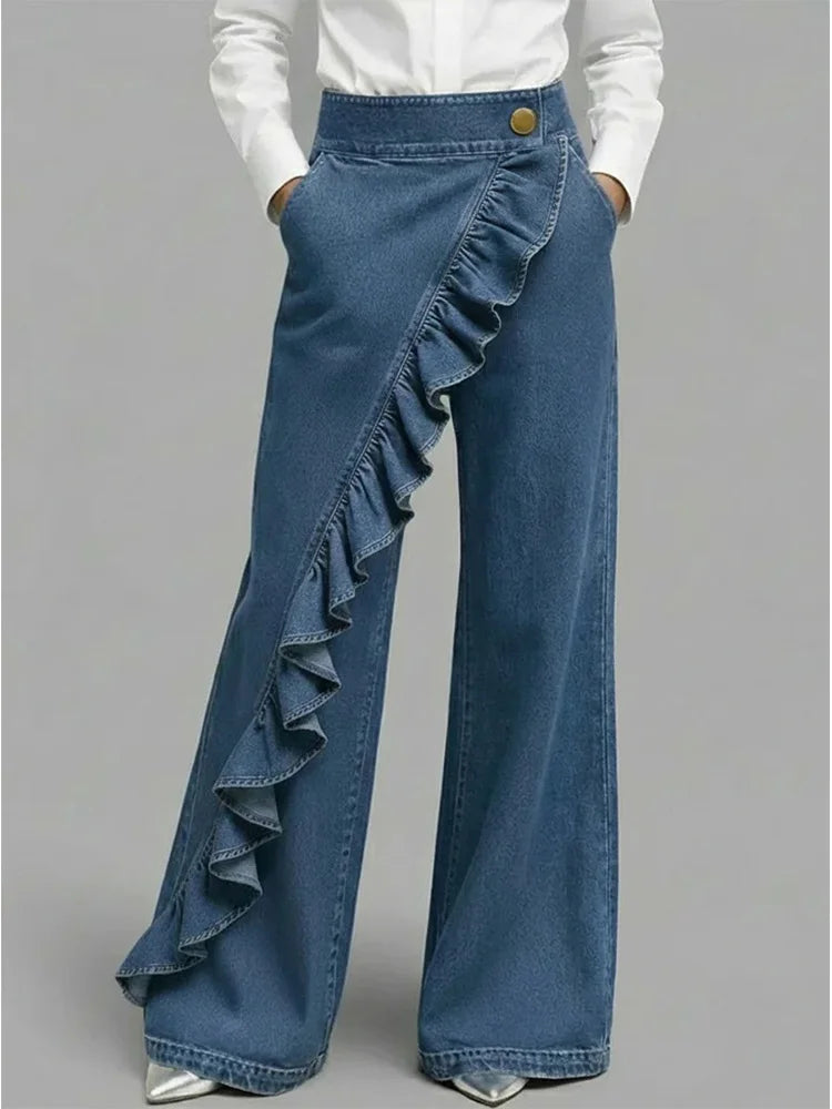 Blue wide-leg jeans with diagonal ruffle overlay and gold button waistband