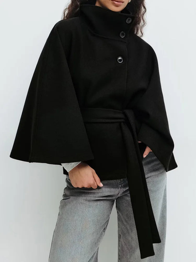 Black wool-blend cape coat with stand collar, snap buttons, and waist tie belt