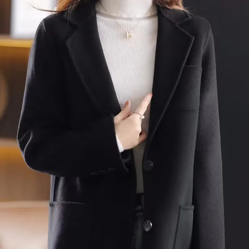 Black wool blazer with notched lapels, two-button front, and front pocket