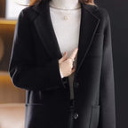 Black wool blazer with notched lapels, two-button front, and front pocket