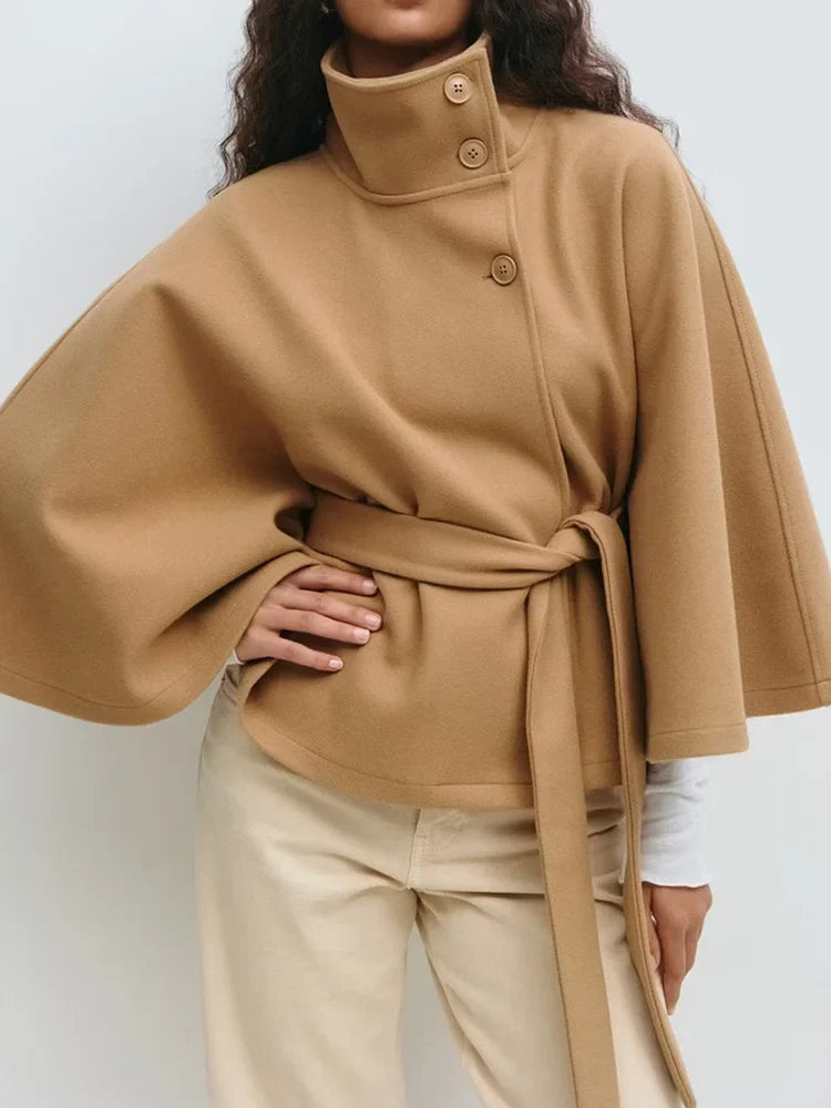 Tan wool-blend cape coat with stand collar, snap buttons, and waist tie belt